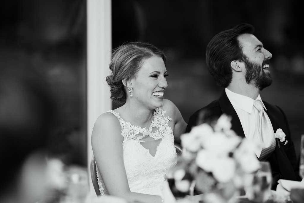 bride and groom laugh during speeches at reception