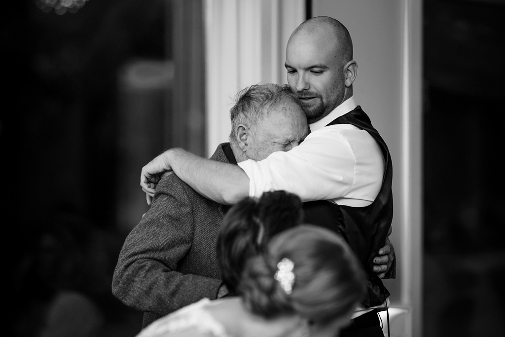 emotional man hugs groomsmen at wedding