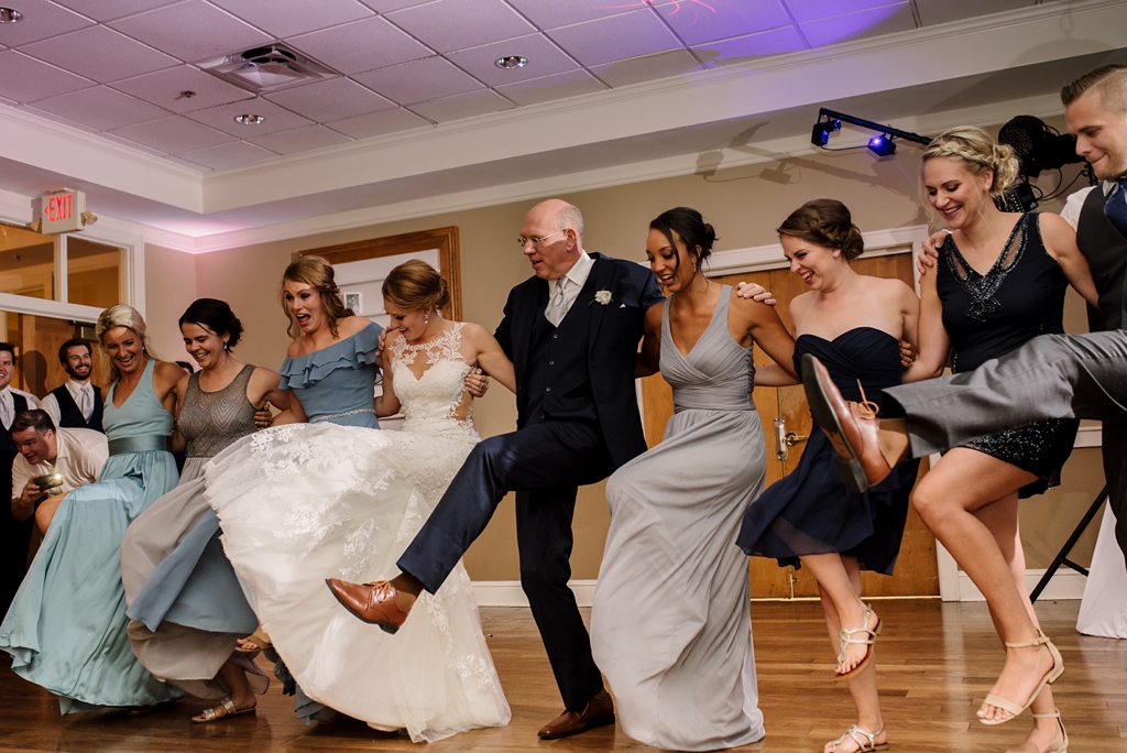 bride and father have kick line with bridal party