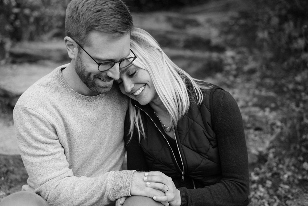 woman puts her head on man's shoulder during engagement session in minneapolis