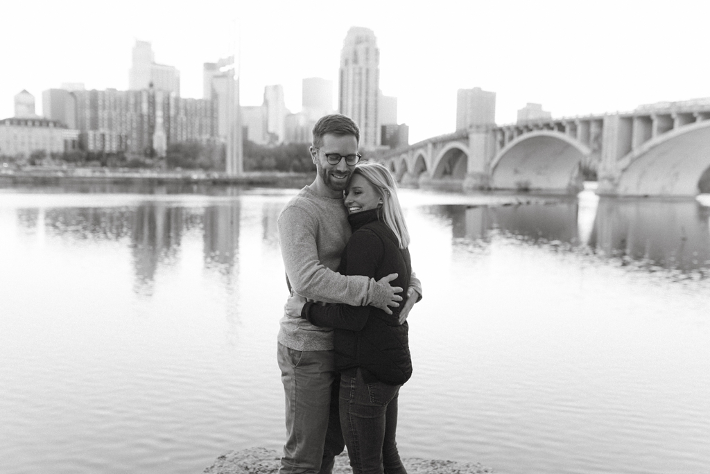 engaged couple beside mississippi river in minneapolis