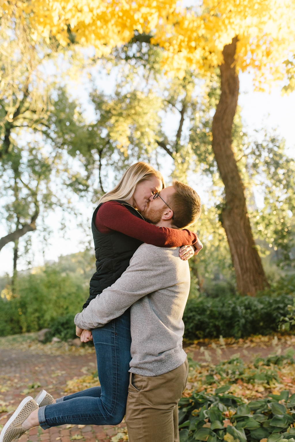 couple kissing at fall minneapolis engagement session