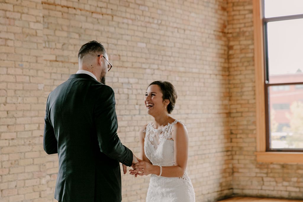 bride laughing at groom's reaction to first look