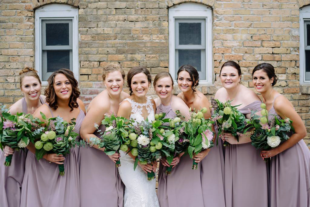 bride and bridesmaids leaning together and smiling