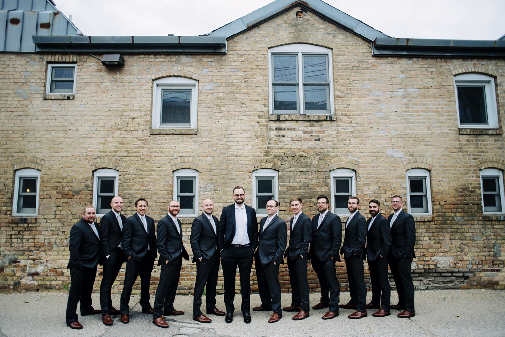 Groomsmen lined up in alley during Day Block Event center wedding