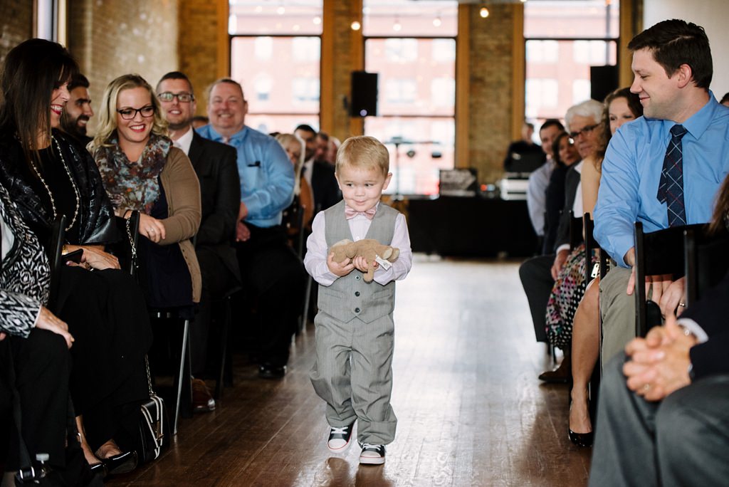 ring bearer carrying toy bear down aisle