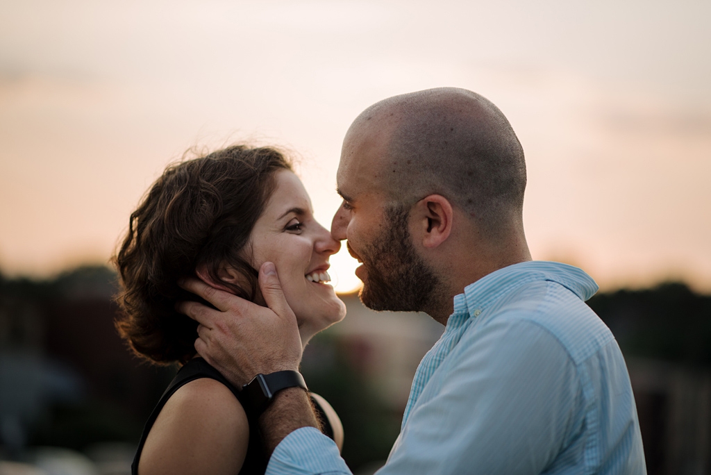 engaged couple kiss at sunset