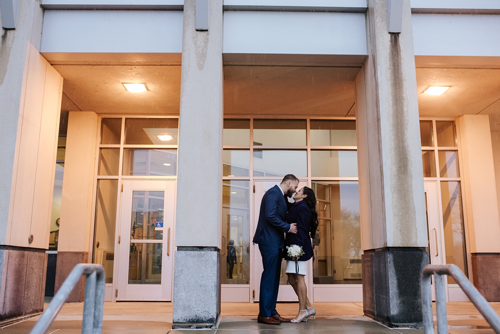 bride and groom kiss outside of minnesota court house