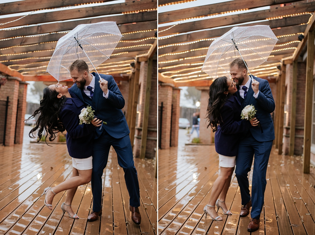 newlyweds laugh under clear umbrella in rain
