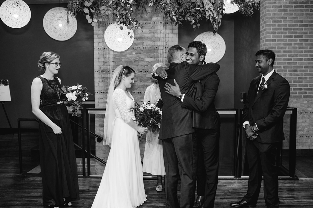 groom hugs father of the bride