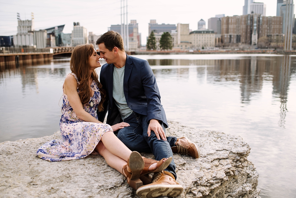 couple sitting on rock beside mississippi river