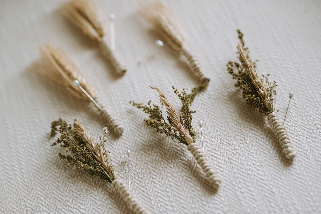 detail of rustic boutonniere with wheat grass