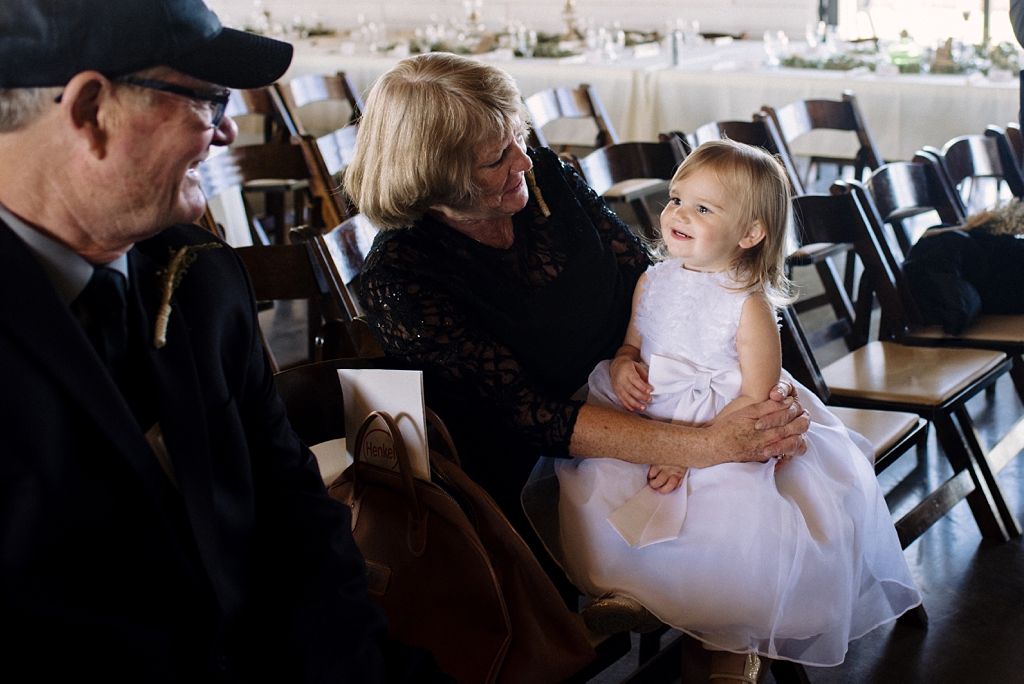 wedding guests wait with flower girl for ceremony