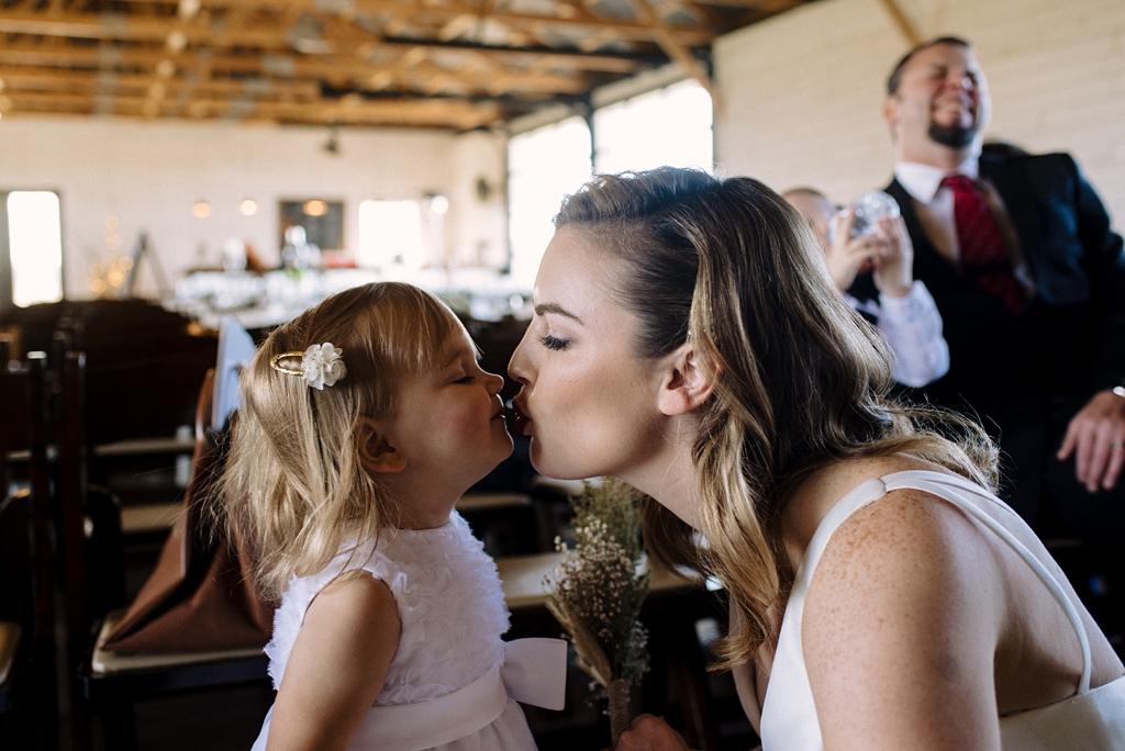 bride kisses flower girl before wedding