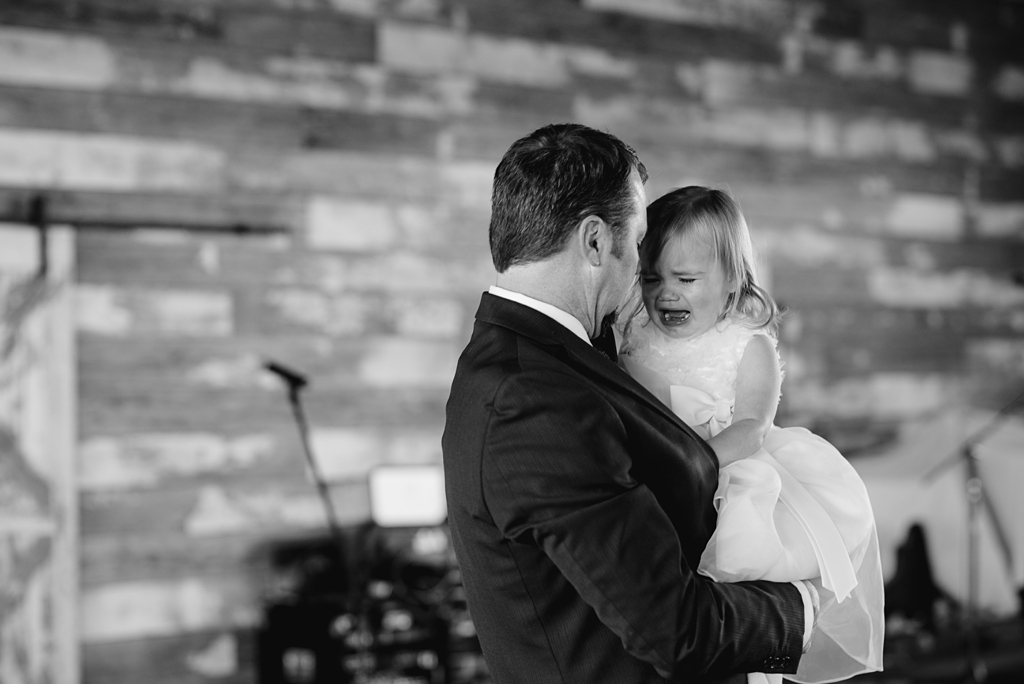 dad holds crying flower girl