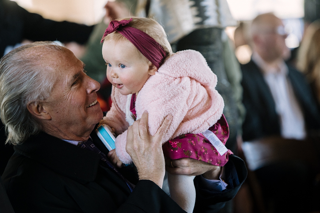 man holds baby girl at minnesota wedding