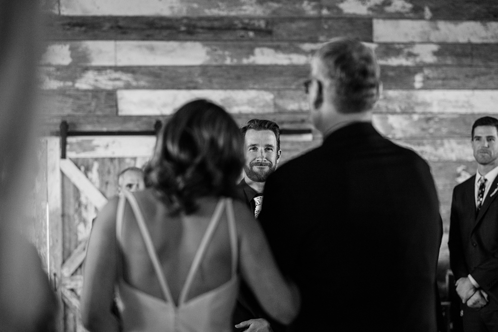 emotional groom watches bride and her father walk down aisle