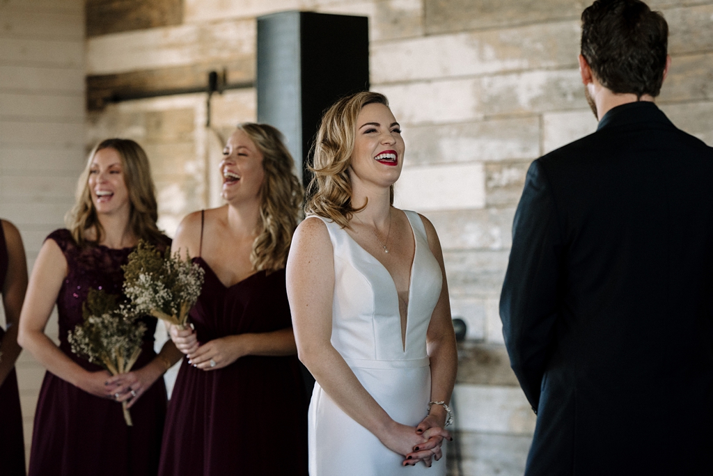 bride and bridesmaids laughing during minnesota wedding