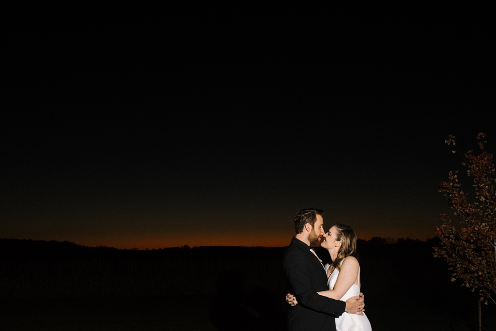 bride and groom kiss at sunset in minnesota