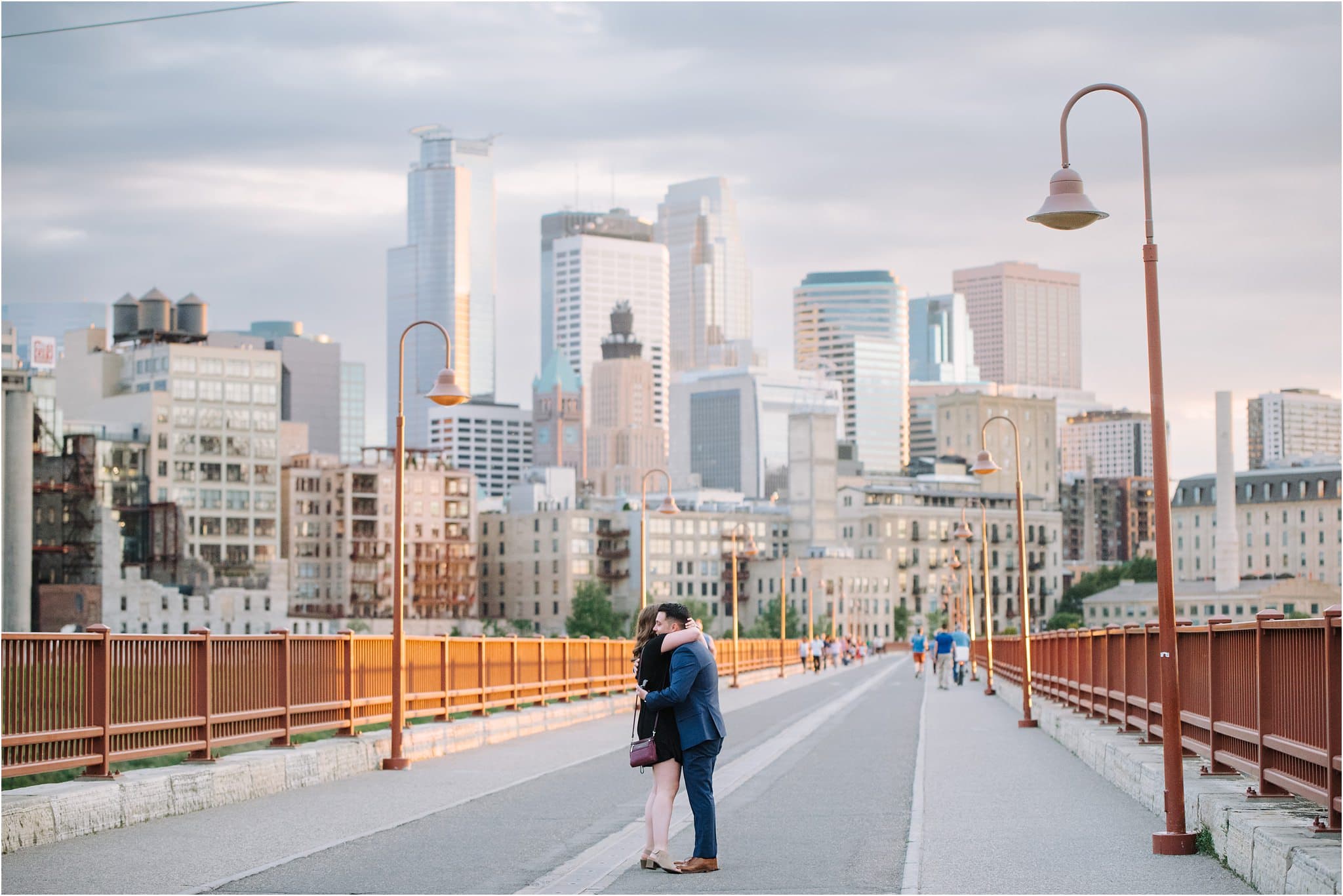 couple embrace in front of minneapolis skyline