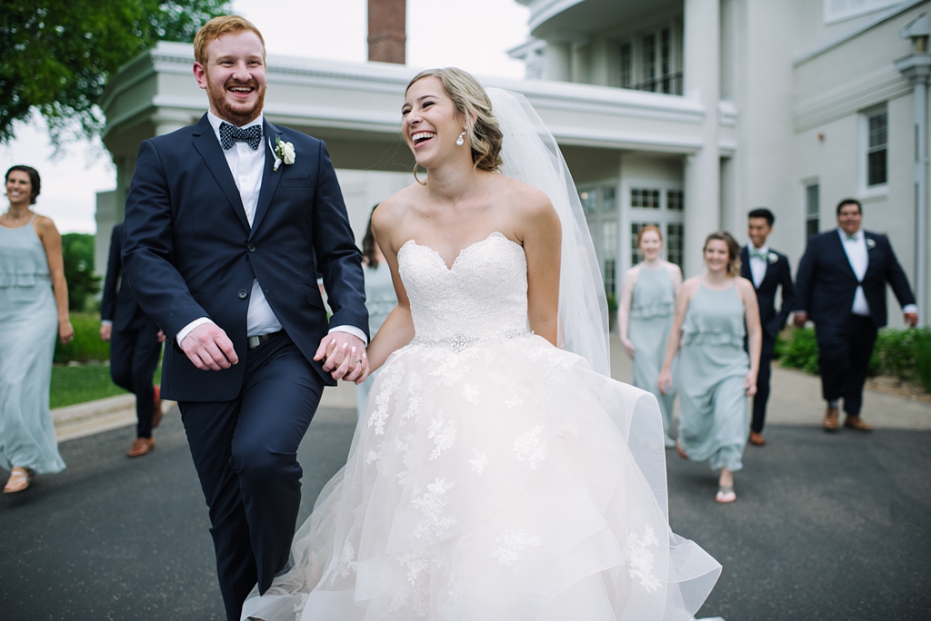 bride and groom laugh walking toward camera