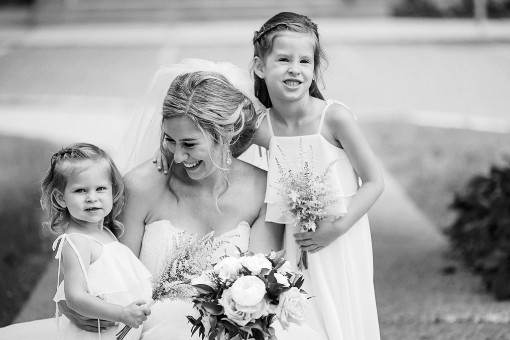 bride smiling and posing with flower girls in Minnesota