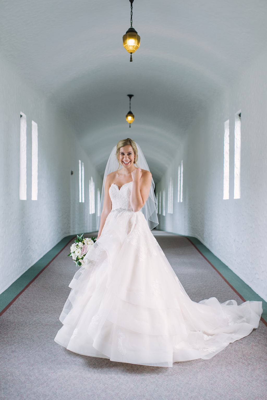 bride laughing in church hallway