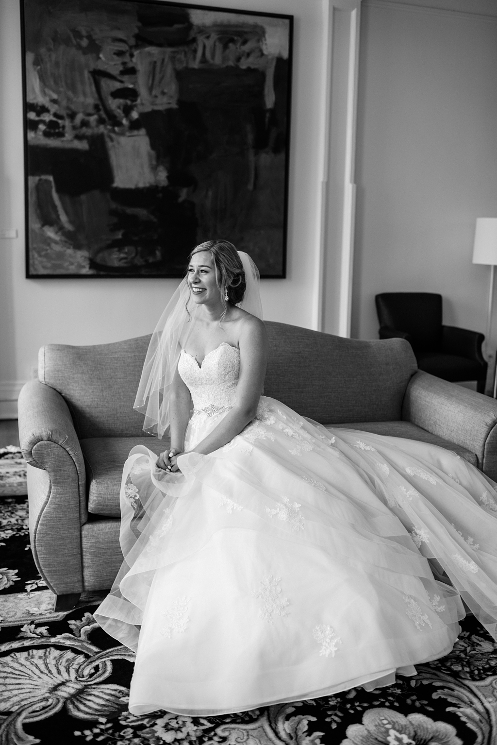 black and white image of bride sitting on couch