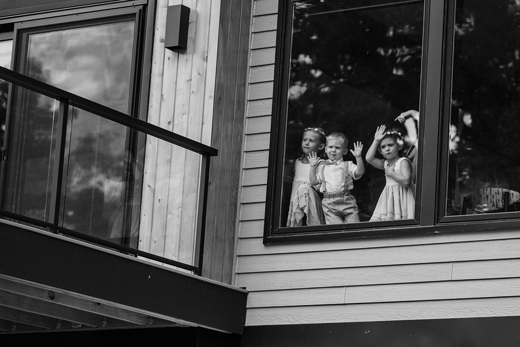 wedding party kids looking out window at guests