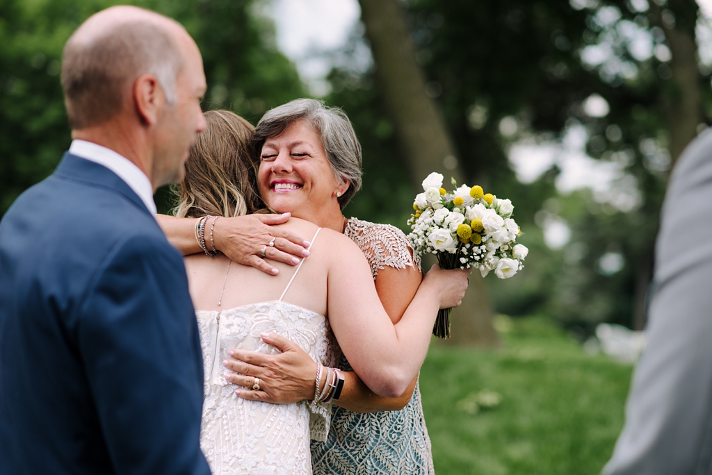 bride hugging mom at backyard ceremony