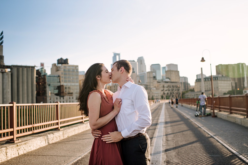 couple kissing on stone arch bridge minneapolis