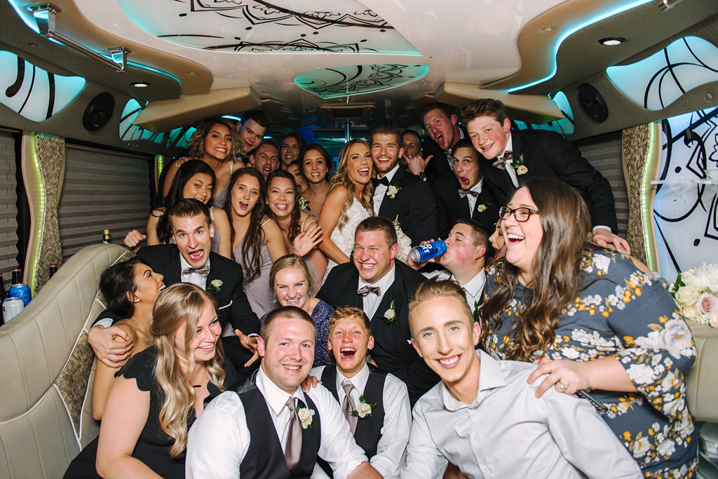 wedding party celebrates in party bus before reception