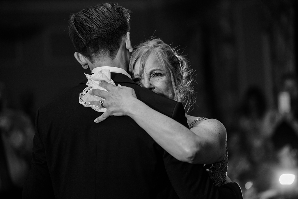teary mother embraces groom during dances