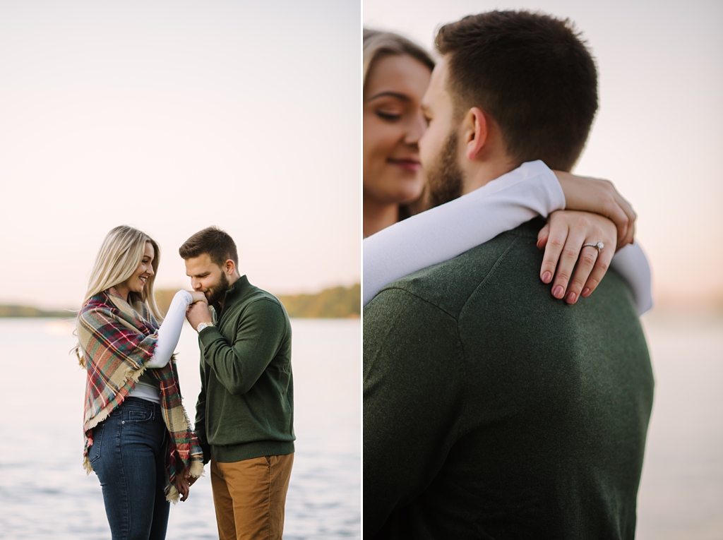 couple embracing lakeside during fall engagement session