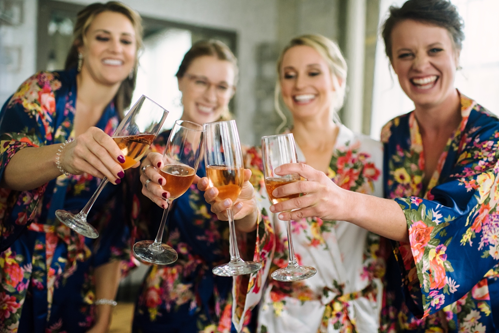 bride and bridesmaids champagne toast while getting ready