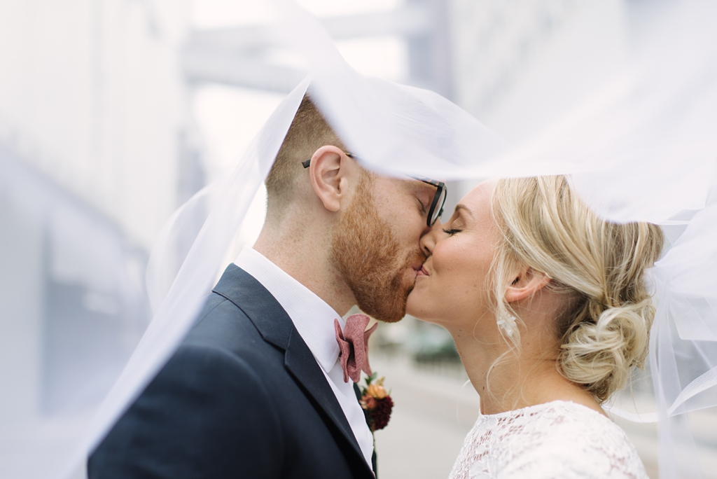 bride and groom kiss under bride's veil