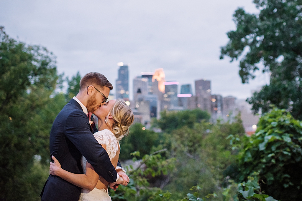 newlyweds kiss in front of minneapolis skyline