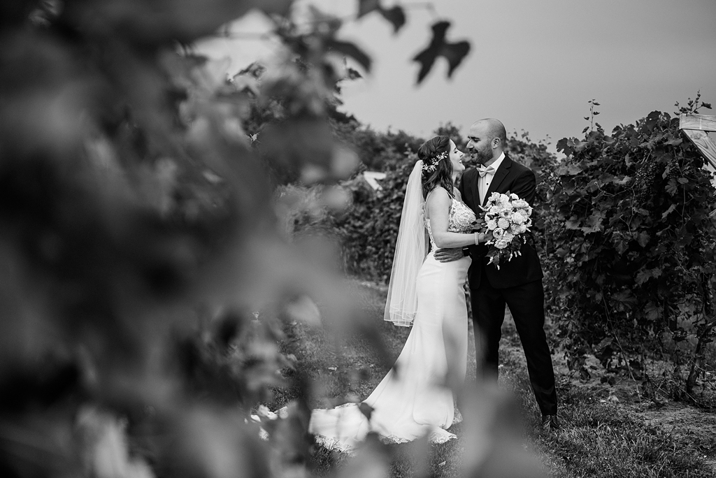 dramatic black and white image of bride and groom in grape field