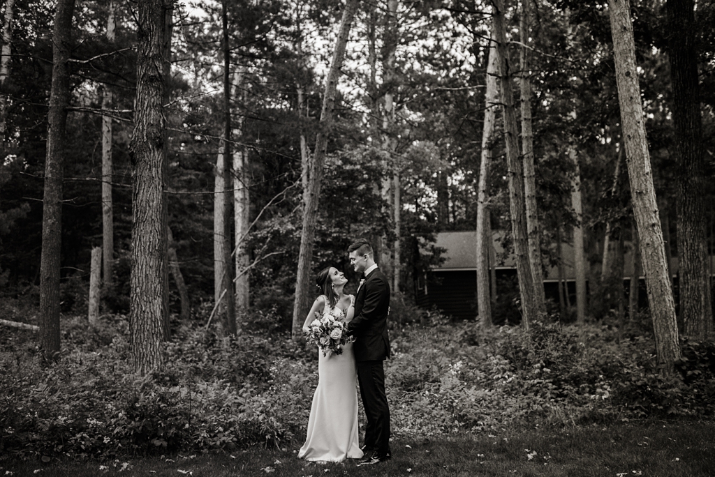 dramatic black and white image of bride and groom in forest