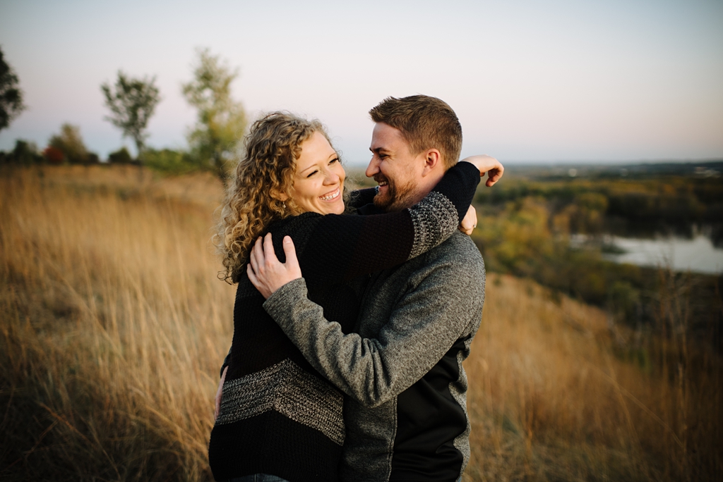 couple hugging and smiling for their fall engagement photos
