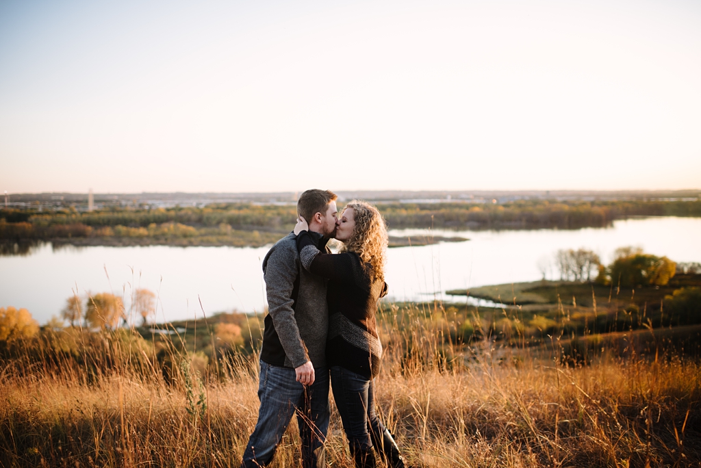 couple kissing in a prairie overlooking the river 
