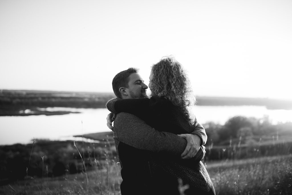 black and white photo of couple hugging in bluffs overlook