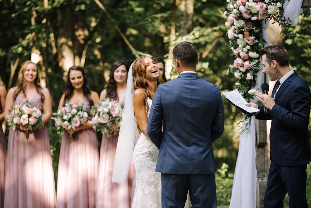 bride laughs during outdoor wedding ceremony at hidden green