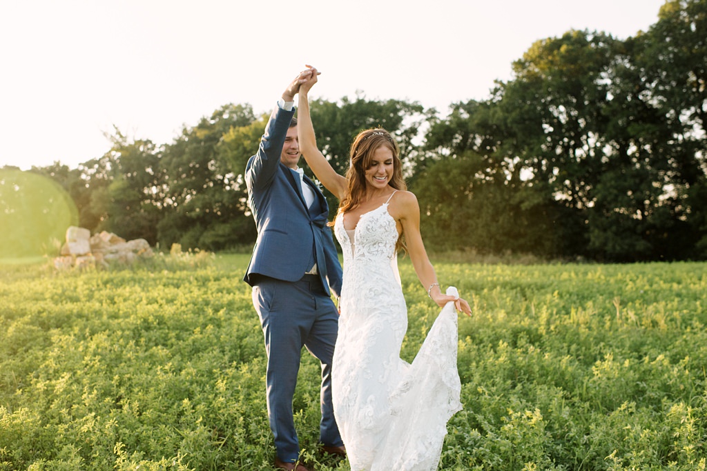 bride and groom dance in a green field