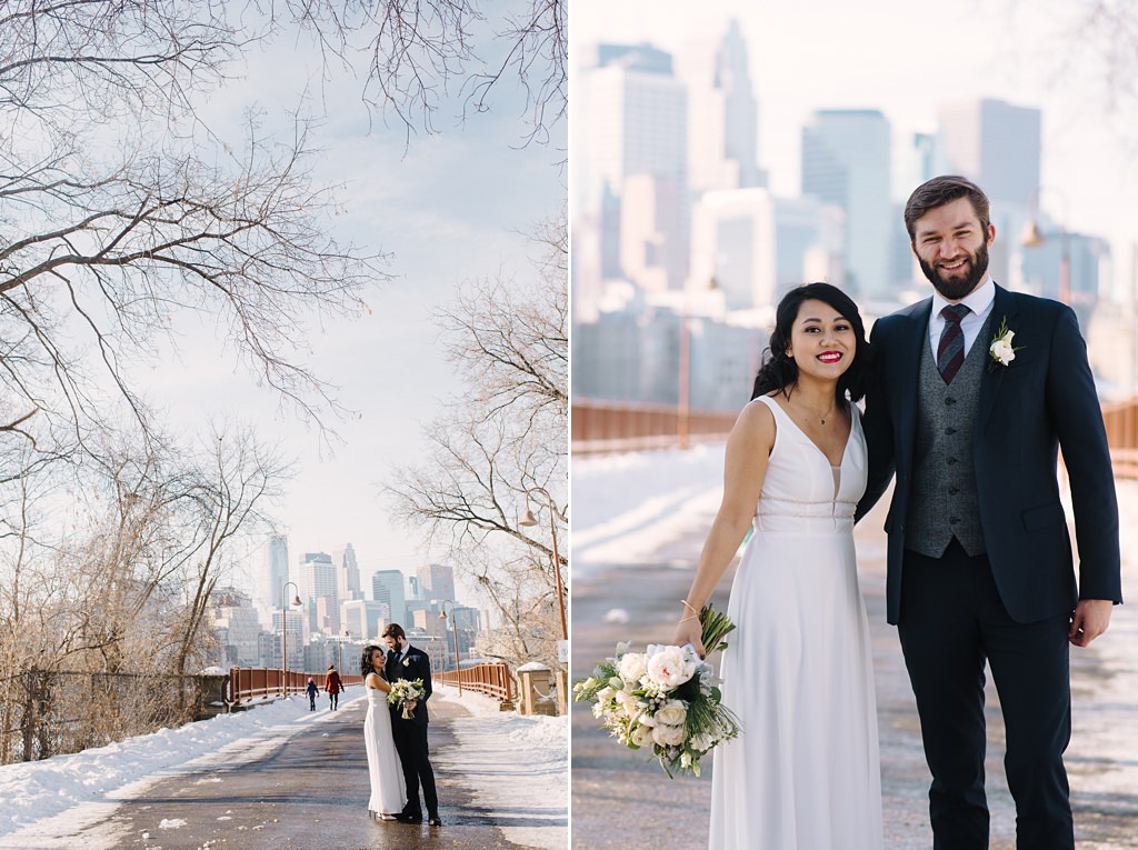 bride and groom embrace on snowy stone arch bridge in minneapolis