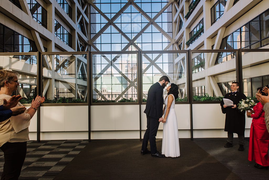 bride and groom share first kiss at minneapolis courthouse wedding