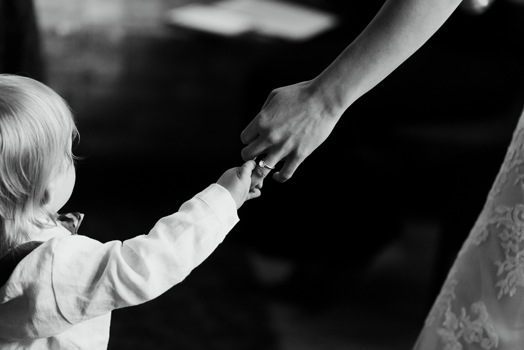 bride holds hands with toddler son