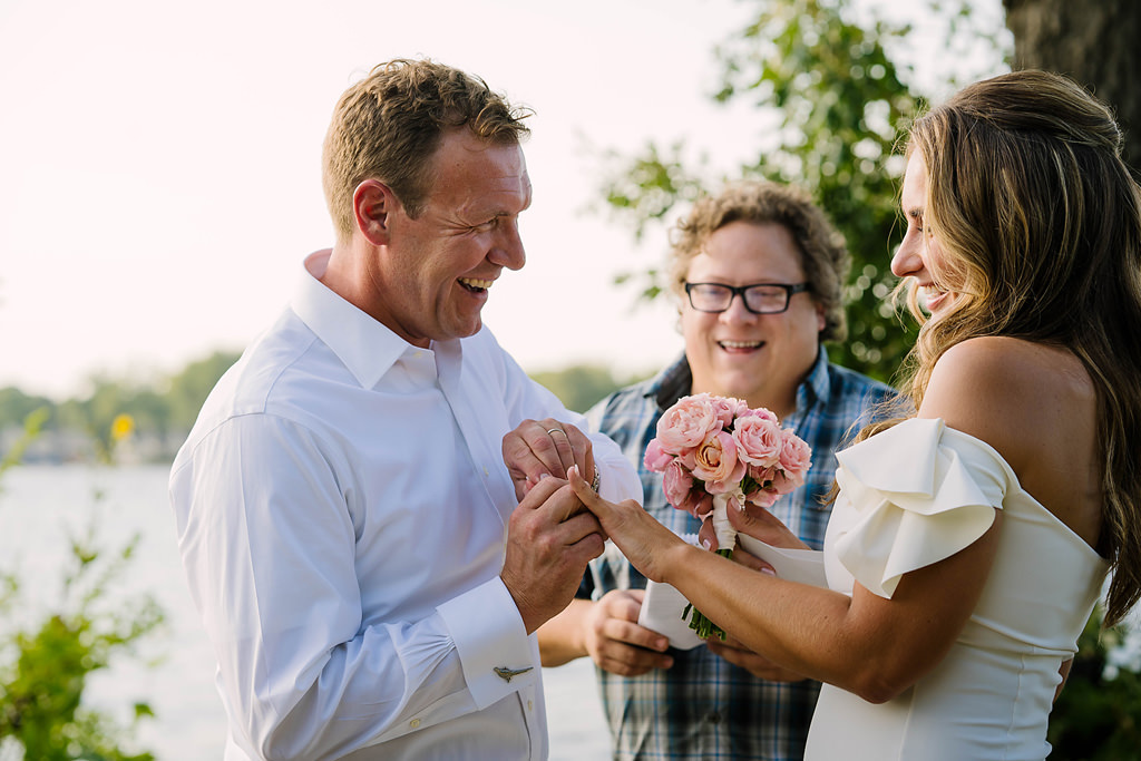 groom slides ring onto bride's finger during excelsior lake elopement