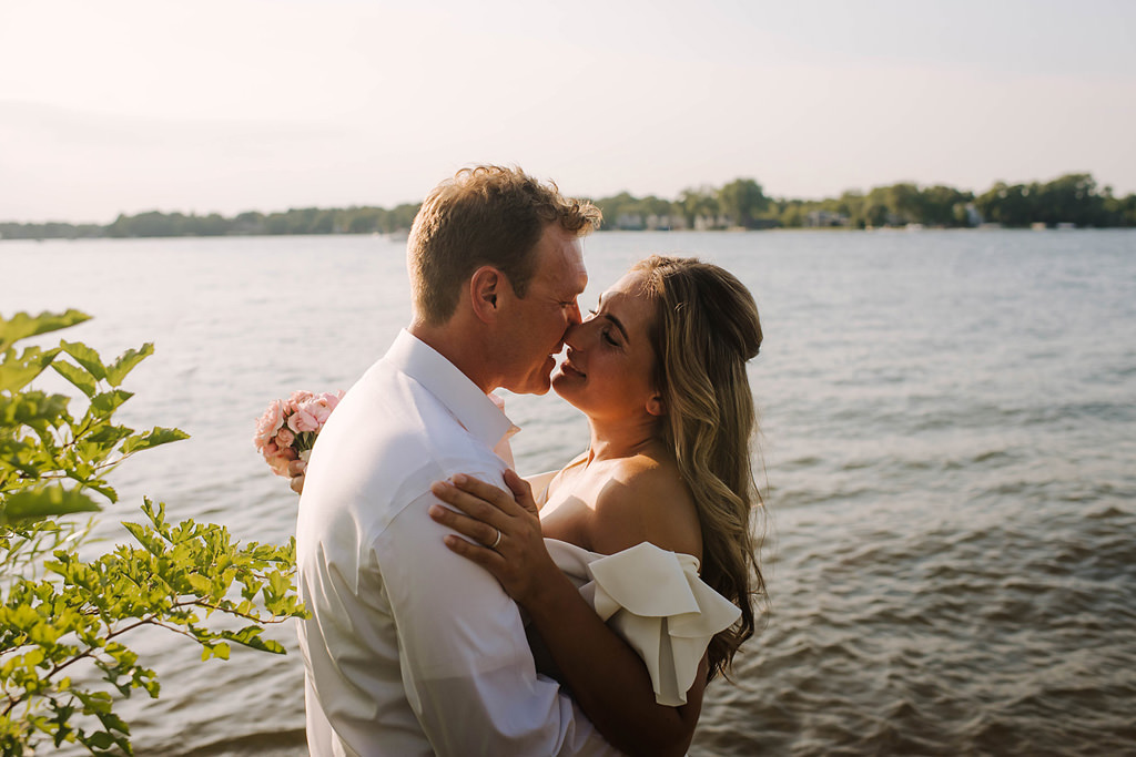 bride and groom kiss after lakeside elopement