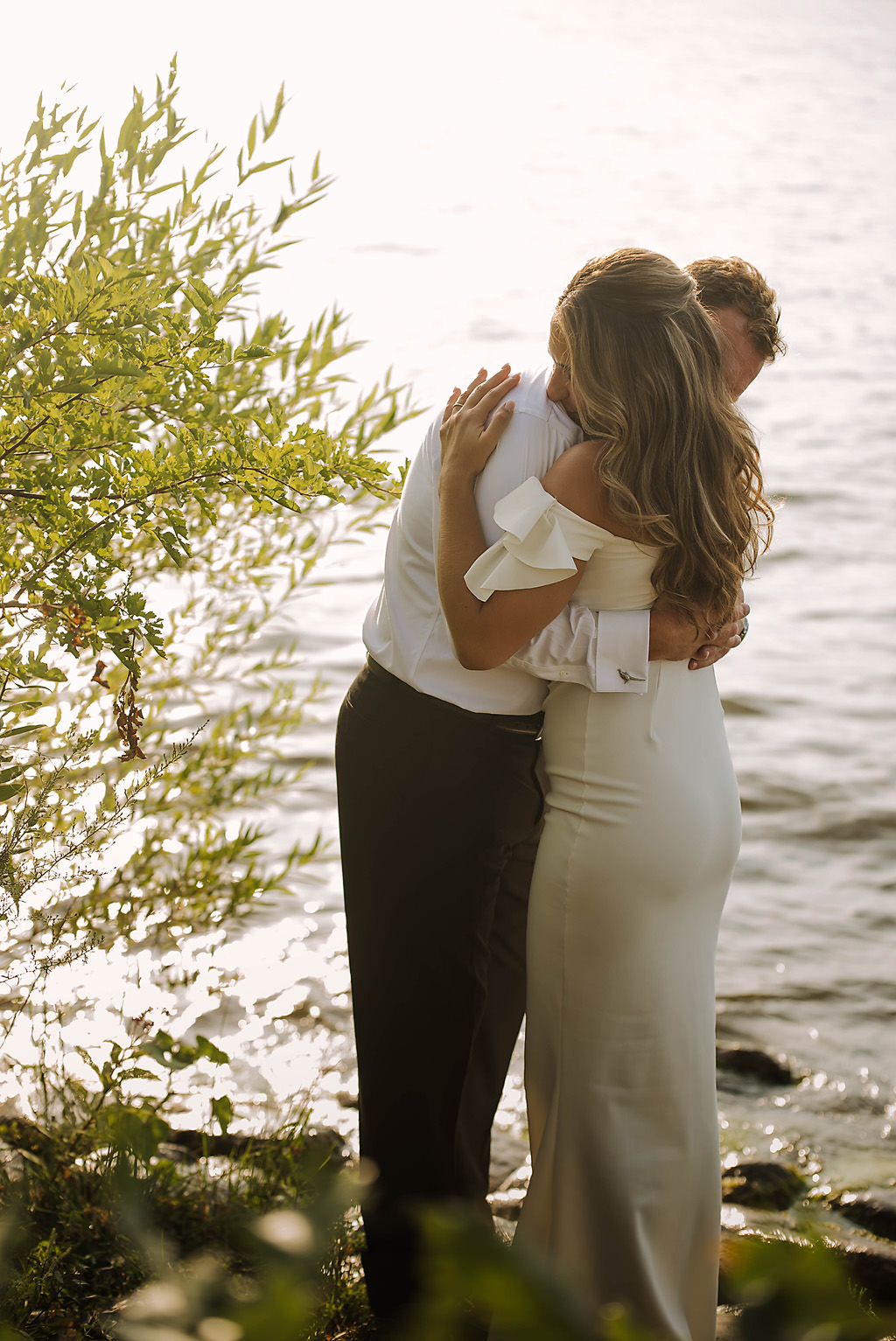 couple embraces beside a lake in minnesota